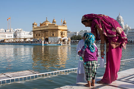 three persons standing in front of body of water during daytime thumbnail