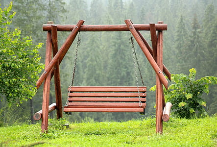 brown wooden swing near green leaf tree thumbnail
