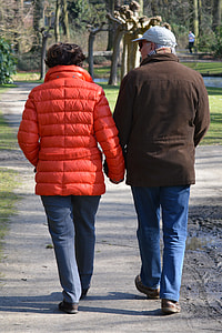 man and woman wearing jacket walking on pathway during daytime thumbnail