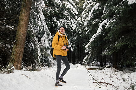 man holding camera on snow-covered woods thumbnail