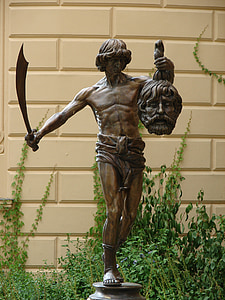 man's profile holding sword and head statuette thumbnail