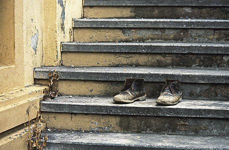 pair of black leather boots on gray concrete stair thumbnail