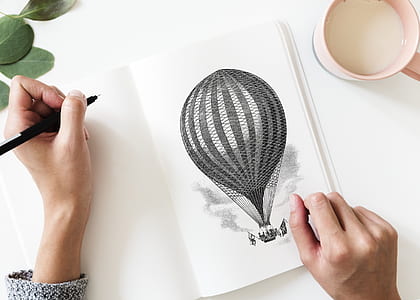 person drawing a hot air balloon on a illustration pad thumbnail