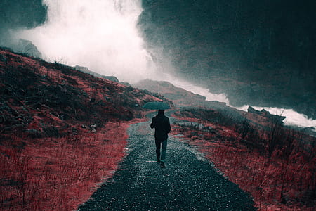 man walking on the road during night time thumbnail