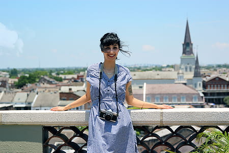 woman in blue dress leaning on balcony thumbnail