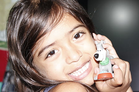 girl holding gray dog figurine thumbnail