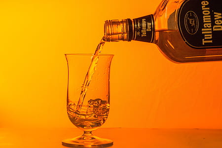 person pouring Tullamore Dew beverage in clear snifter glass thumbnail