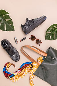 pair of gray Nike low-top sneakers beside black leather tote bag thumbnail
