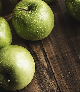 photo of green apples on brown wooden surface thumbnail
