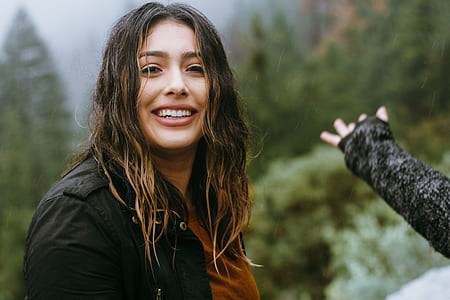 woman standing next to trees thumbnail