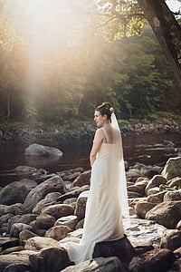 woman wearing white wedding gown standing near river thumbnail