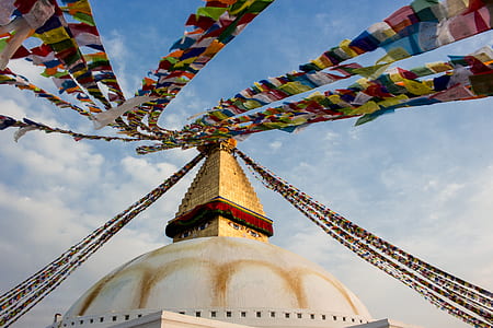 white and brown concrete dome building with buntings under blue sky and white clouds at daytime thumbnail