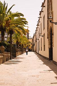 man in white tops and black bottoms walking in street thumbnail