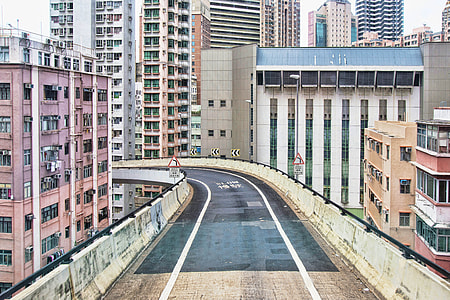 photo of concrete road surrounded by buildings thumbnail