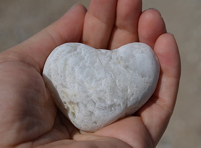 person holding white heart stone thumbnail