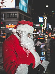 shallow focus photography of person in Santa Claus costume in the middle of the city thumbnail
