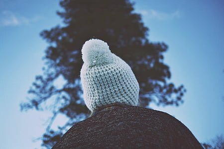 person wearing white beanie looking at tree thumbnail