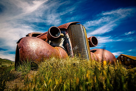 rusted vintage brown car under cloudy sky during daytime thumbnail