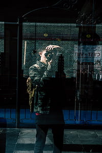 reflection of man holding DSLR camera thumbnail