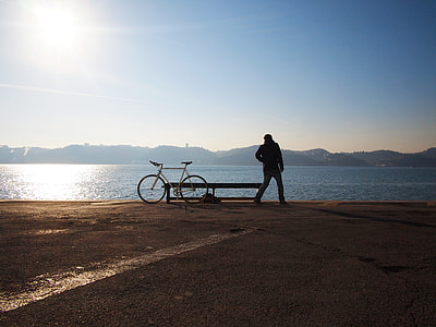silhouette of man beside white fixie bike watching ocean water view during daytime thumbnail