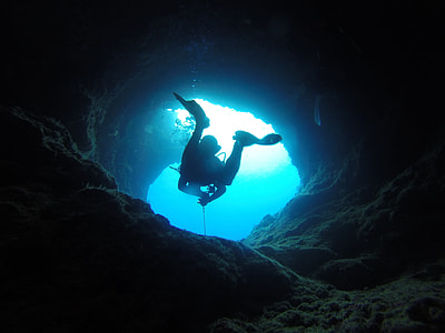 person in scuba diving suit in cave underwater thumbnail