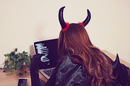 woman wearing black-and-red costume while using laptop thumbnail