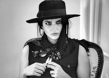 grayscale photography of woman in black collared sleeveless top with fedora thumbnail