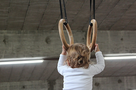 baby holding on two brown rings thumbnail
