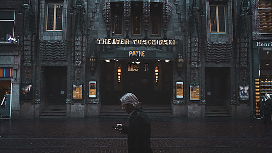 man standing in front of theater building thumbnail
