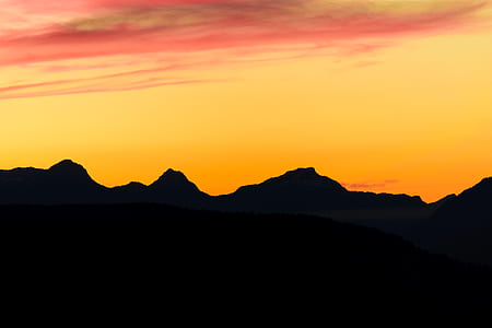 silhouette of mountains during orange sky thumbnail