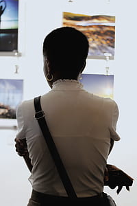 back of standing woman holding smartphone thumbnail