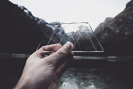person holding clear glass near body of water thumbnail