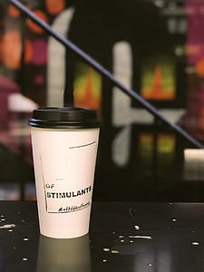 white and black paper cup on table thumbnail
