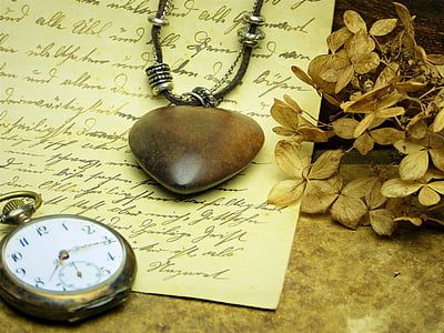 silver-colored pocket watch near brown heart pendant necklace on printer paper thumbnail