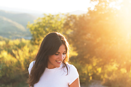 A girl with a smile dressed in a white t-shirt thumbnail