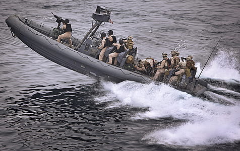 navy army on gray power boat thumbnail