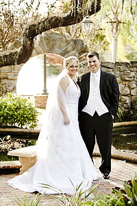 woman wearing white wedding dress and man wearing wedding outfit smiling thumbnail