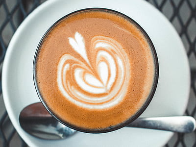 latte-filled cup with stainless steel teaspoon on saucer thumbnail