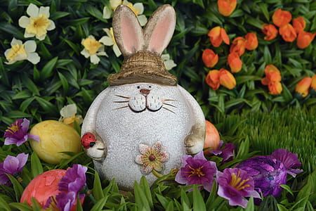 rabbit statue surrounded by flowers thumbnail