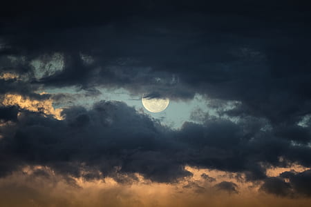 full moon behind dark clouds thumbnail
