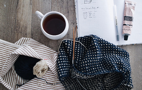white cup on table beside book and cloth thumbnail
