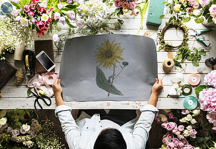 man holding sunflower painting front of table thumbnail