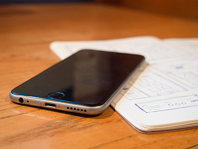 space gray iPhone 6 on top of brown wooden furniture thumbnail