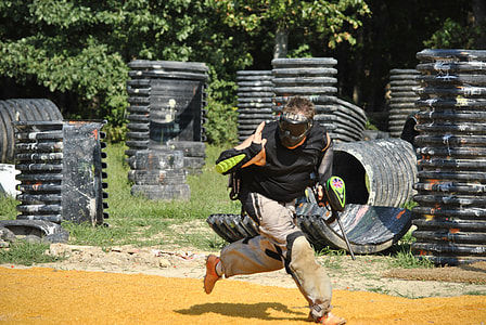 man running and holding paint ball gun at during daytime thumbnail