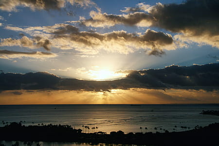 photography of ocean under gray clouds at golden hour thumbnail