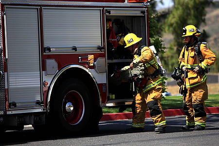 two fire fighters standing near fire truck thumbnail