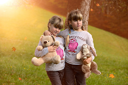two girls holding animal plush toys thumbnail