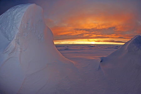 photo of land covered with snow during golden hour thumbnail