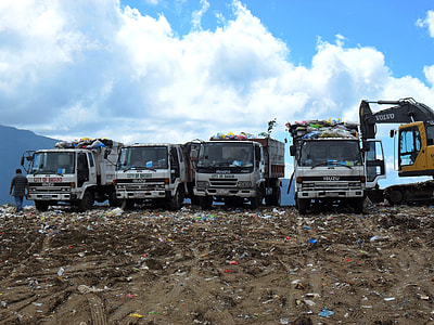 four white dump trucks and 1 yellow front loader thumbnail