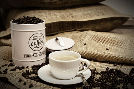 white ceramic cup and saucer beside coffee beans thumbnail